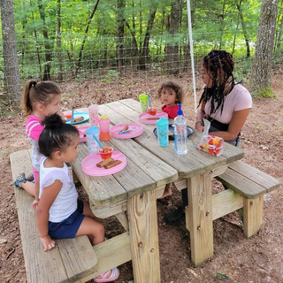 An adult and children sharing a school day outdoors.