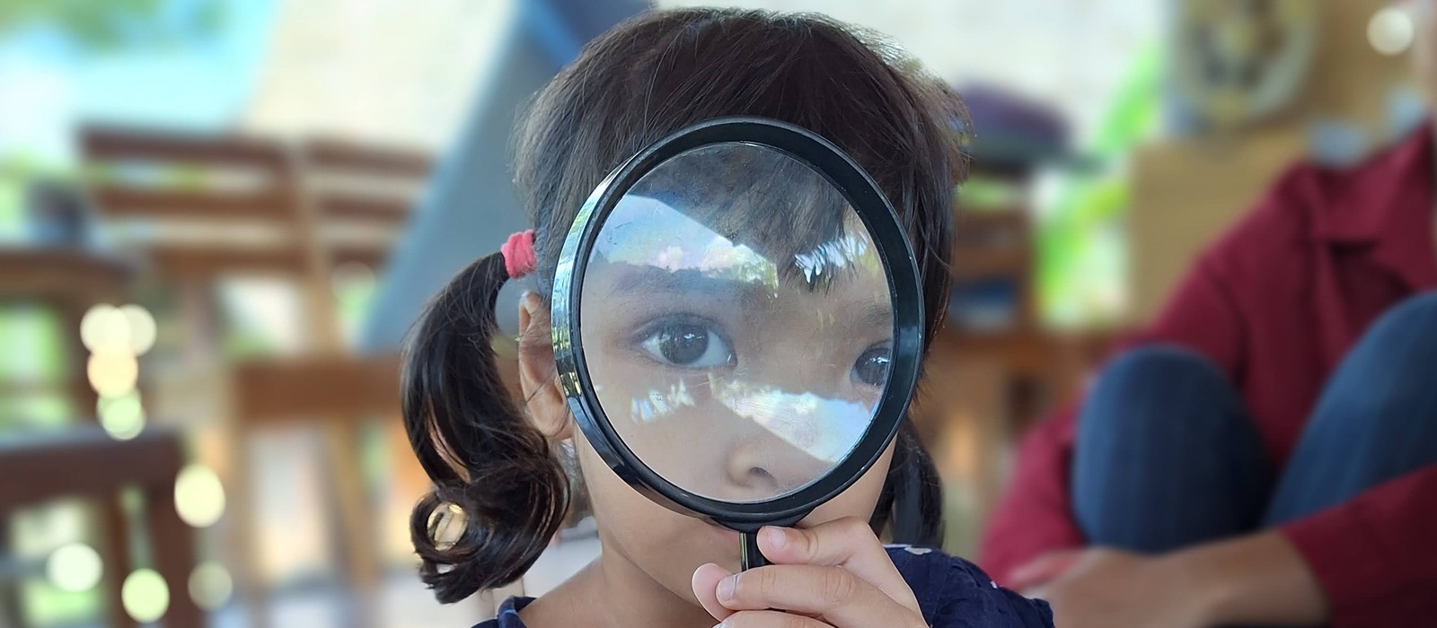A child looks through a magnifying glass.